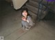 A woman sitting on the ground next to a horseshoe.