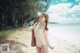 A woman in a bathing suit standing on a beach.