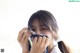 A young woman covering her face with a scarf.